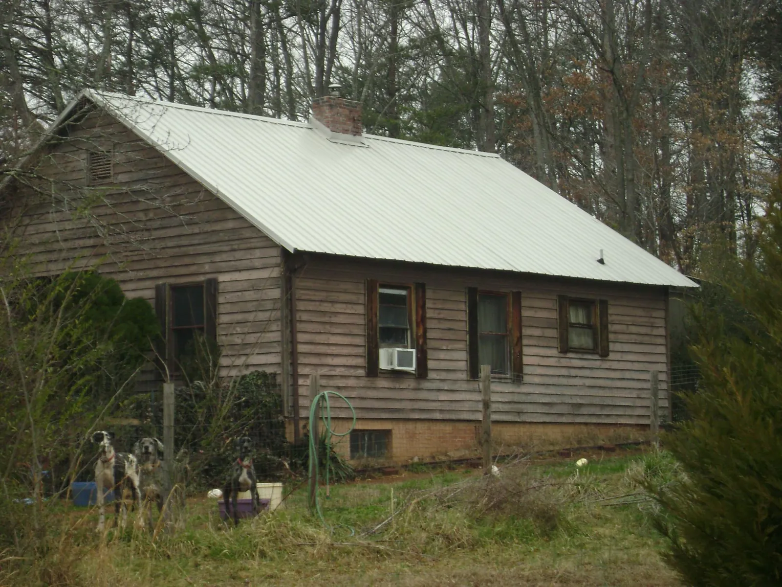 White metal roof on an old wood sided farmhouse, from a Metal Roof Installation job in Noble